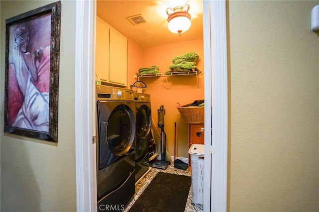 laundry room featuring cabinets and washing machine and clothes dryer