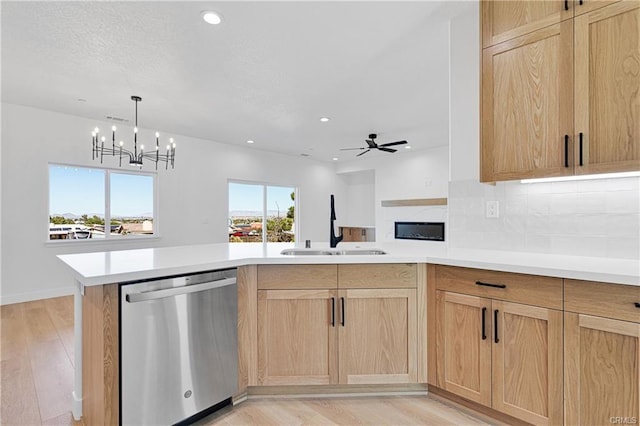 kitchen with light hardwood / wood-style floors, stainless steel dishwasher, light brown cabinetry, and sink