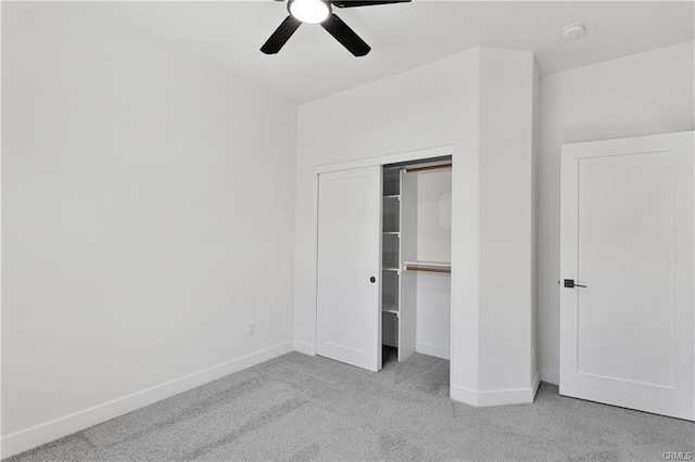 unfurnished bedroom featuring light colored carpet, a closet, and ceiling fan