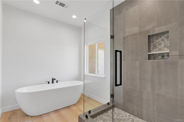 bathroom featuring separate shower and tub and hardwood / wood-style floors