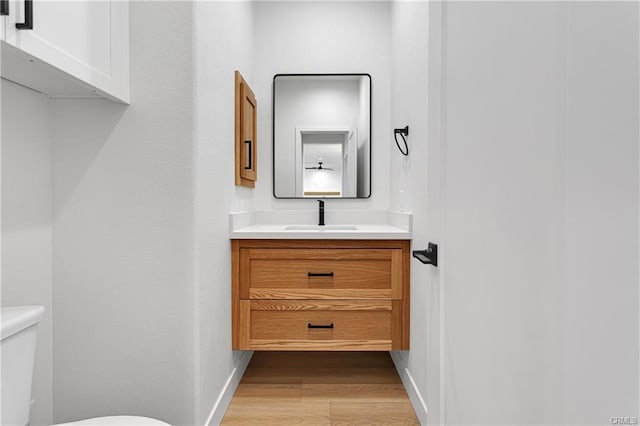 bathroom featuring vanity, toilet, and hardwood / wood-style floors