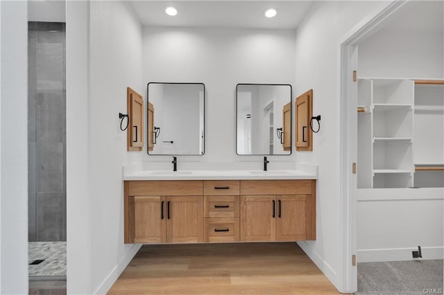 18554 Temecula Ave, Hesperia, CA 92345 - bathroom featuring double vanity, wood finished floors, recessed lighting, tiled shower, and baseboards