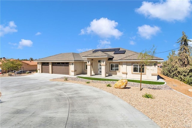 prairie-style house featuring a garage and solar panels