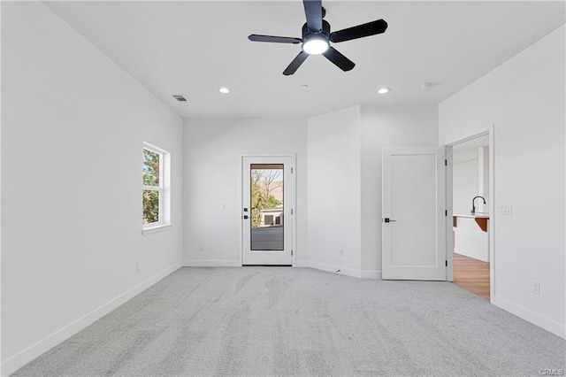 carpeted spare room with ceiling fan