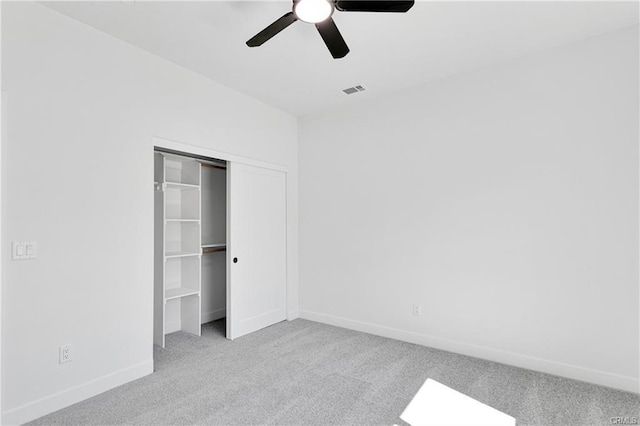 unfurnished bedroom with light carpet, a closet, and ceiling fan