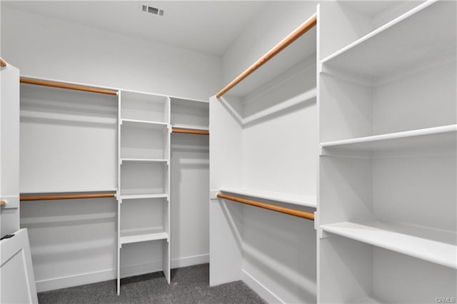 spacious closet featuring dark carpet