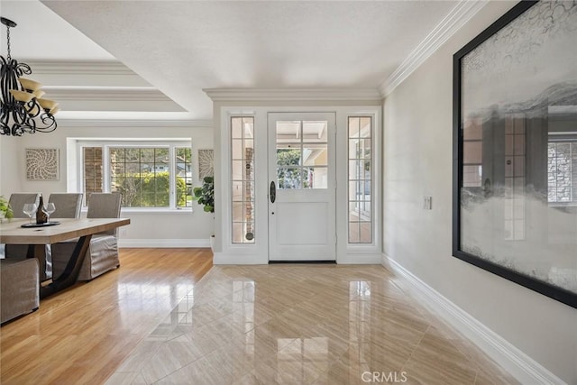 entrance foyer featuring ornamental molding and a chandelier