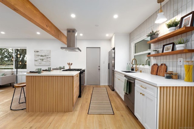 kitchen featuring appliances with stainless steel finishes, pendant lighting, sink, white cabinets, and island exhaust hood