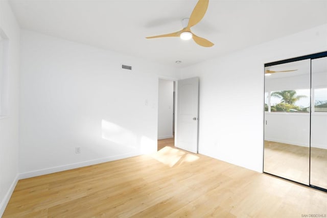 unfurnished bedroom featuring light hardwood / wood-style floors, a closet, and ceiling fan