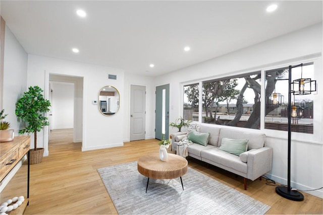 living room featuring plenty of natural light and light hardwood / wood-style flooring