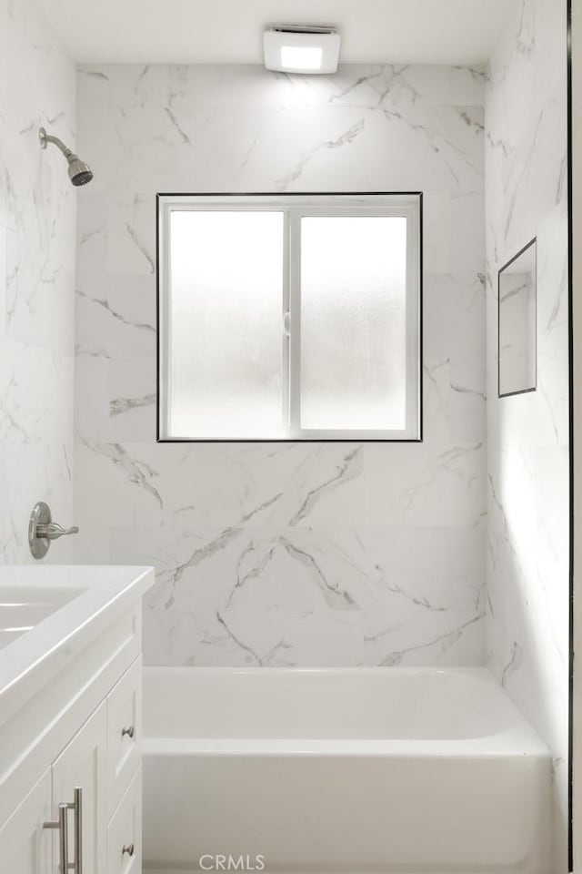 bathroom featuring vanity and tiled shower / bath