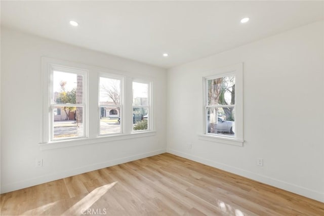 empty room with a healthy amount of sunlight and light hardwood / wood-style floors