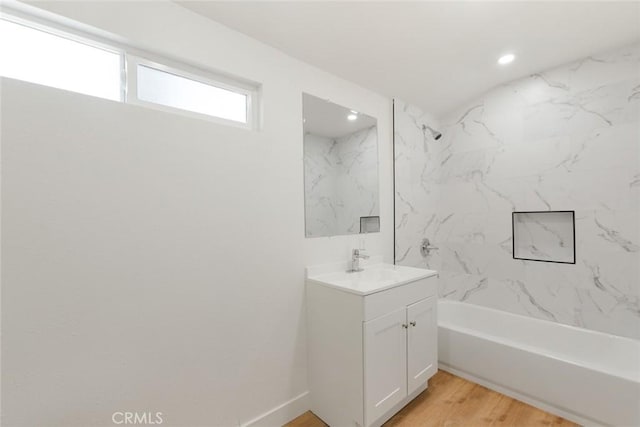 bathroom featuring vanity, tiled shower / bath combo, and hardwood / wood-style flooring