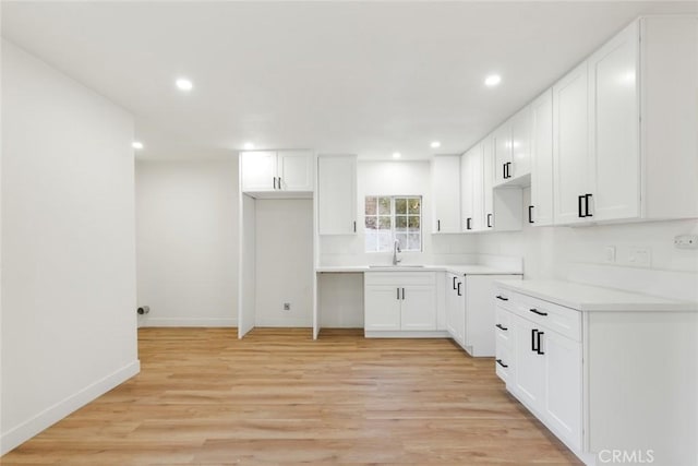 kitchen featuring sink, light hardwood / wood-style floors, and white cabinets