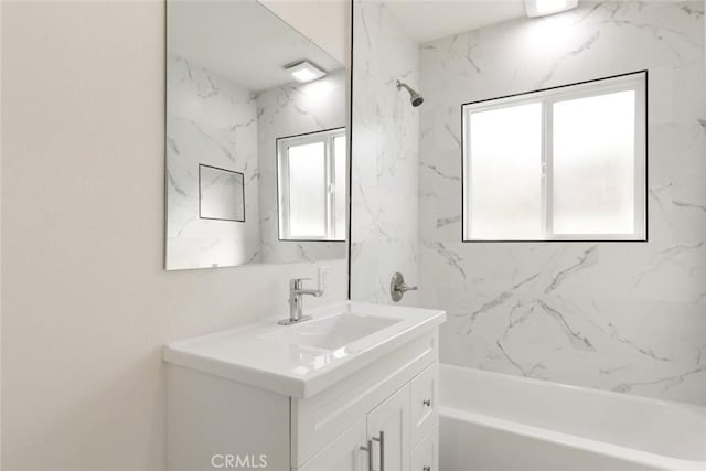 bathroom featuring vanity and tiled shower / bath