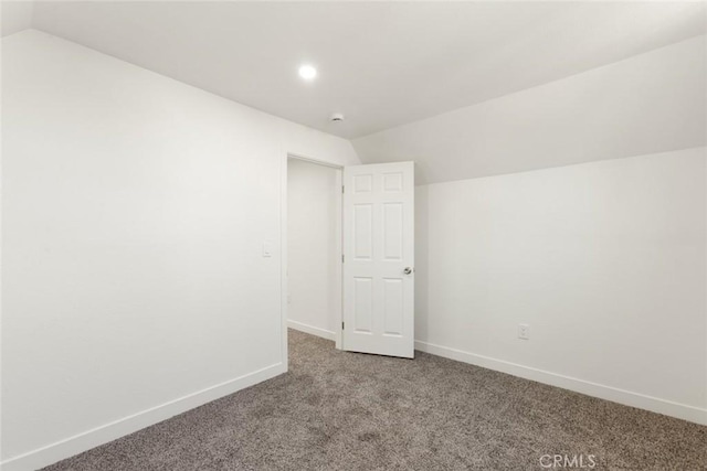 carpeted spare room with lofted ceiling