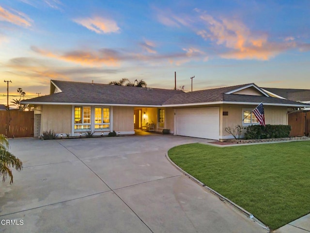 ranch-style home featuring a garage and a yard