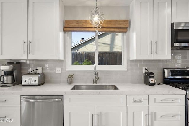 kitchen with stainless steel appliances, sink, and white cabinets