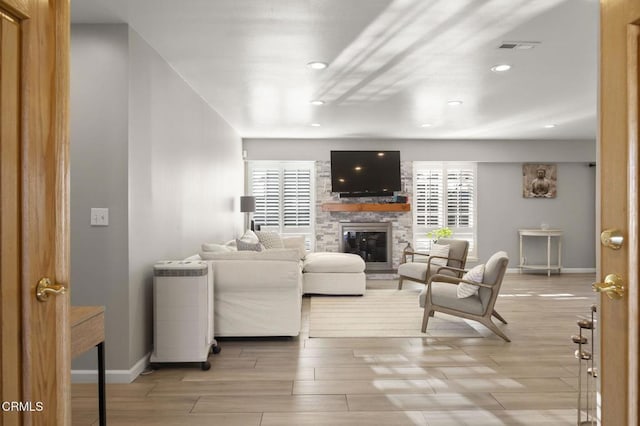 living room with a fireplace and light wood-type flooring