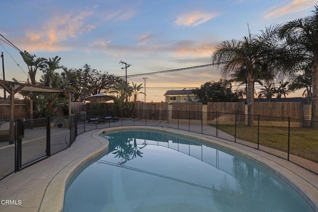 pool at dusk with a patio area