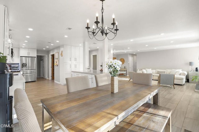 dining space with a chandelier and light wood-type flooring