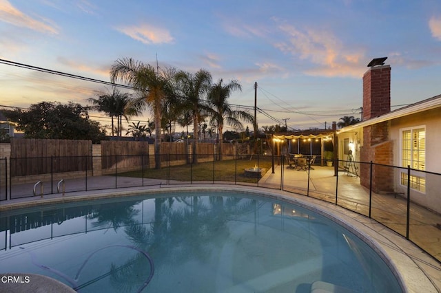 pool at dusk featuring a patio area