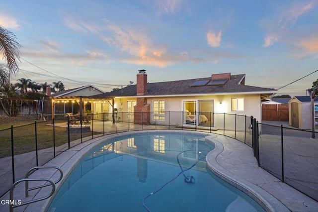 pool at dusk featuring a patio