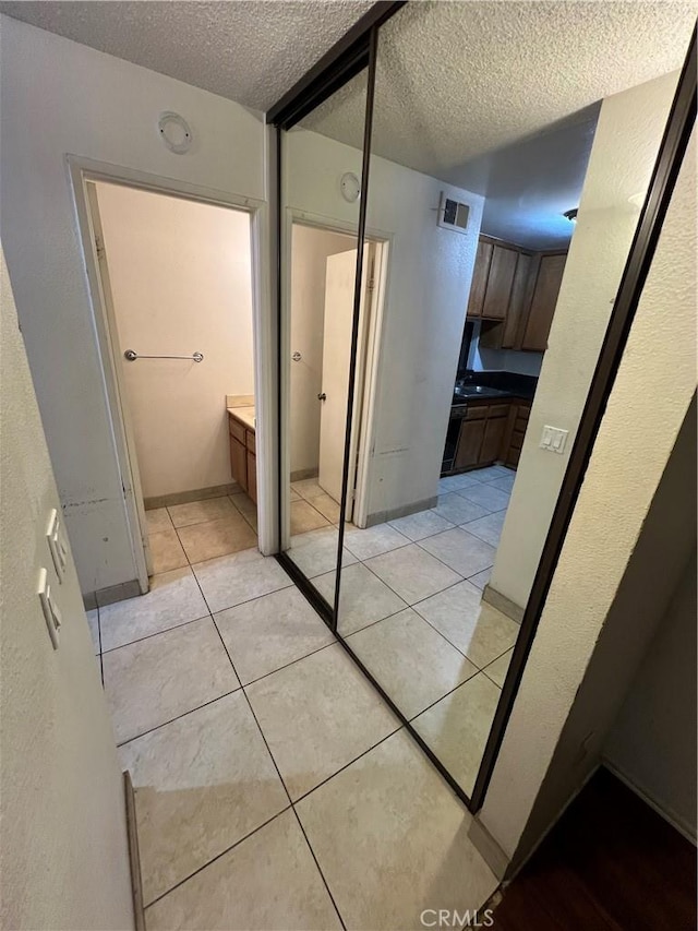 interior space featuring tile patterned flooring and a textured ceiling