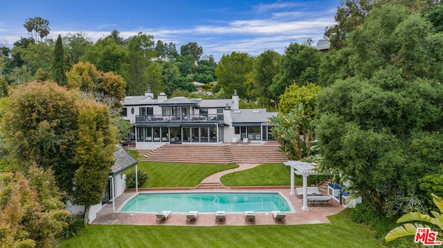 rear view of house with a yard, a pergola, and a patio