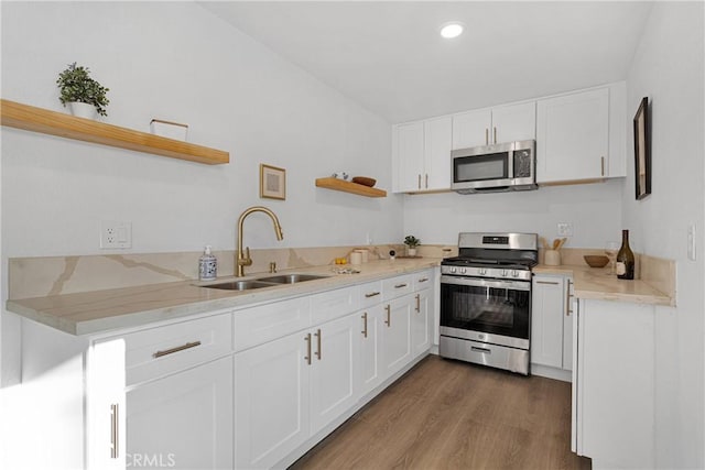 kitchen featuring white cabinetry, appliances with stainless steel finishes, sink, and hardwood / wood-style floors