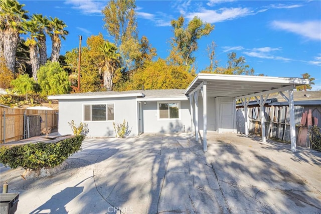 back of house featuring a carport