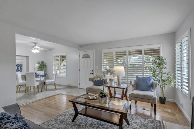 living room featuring ceiling fan, a healthy amount of sunlight, and light wood-type flooring