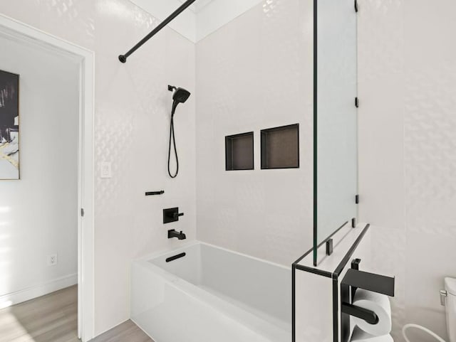 bathroom featuring wood-type flooring, bathing tub / shower combination, and toilet