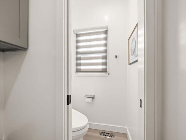 bathroom with hardwood / wood-style floors and toilet