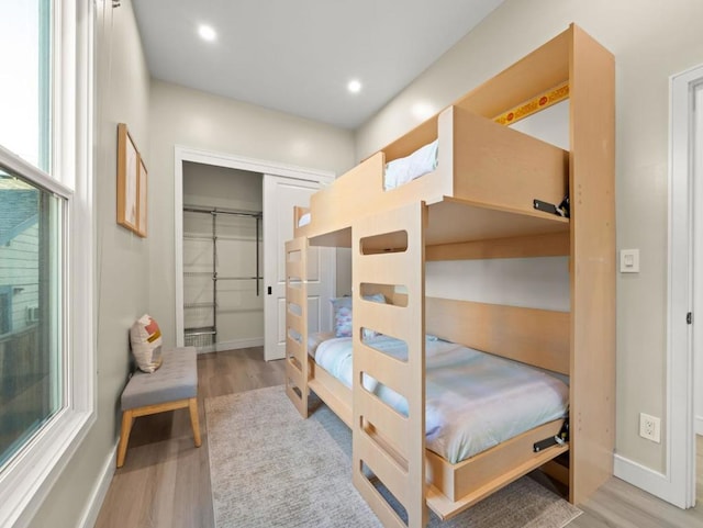 bedroom featuring multiple windows, a closet, and light wood-type flooring