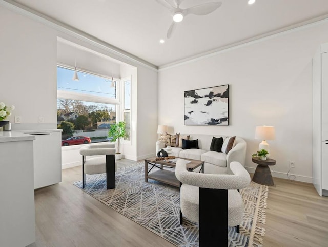 living room featuring crown molding, ceiling fan, and light hardwood / wood-style floors