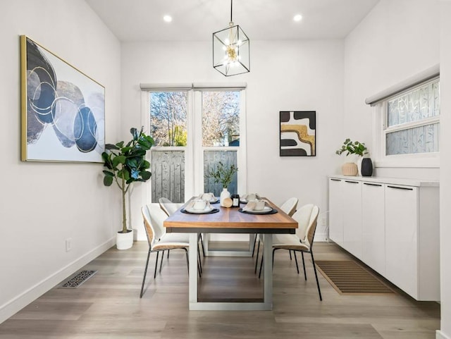 dining room with light hardwood / wood-style floors and a chandelier