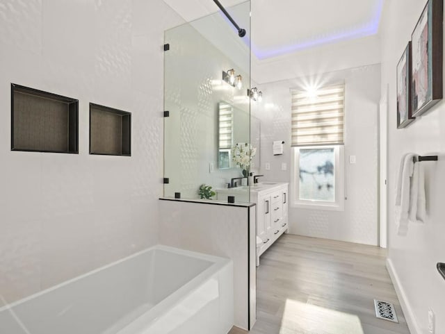 bathroom featuring vanity, separate shower and tub, and wood-type flooring