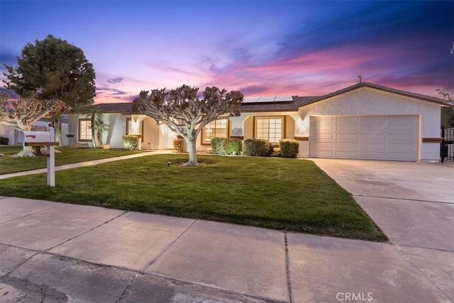 single story home featuring a garage, a lawn, and solar panels