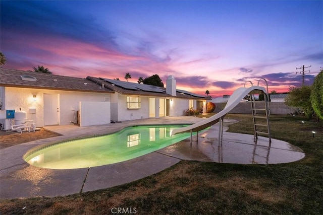 2173 N Viminal Rd, Palm Springs, CA 92262 - pool at dusk with a water slide, a patio, and a fenced backyard