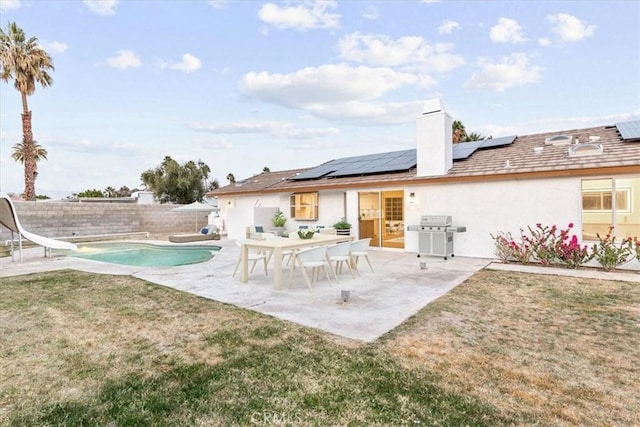 2173 N Viminal Rd, Palm Springs, CA 92262 - back of property featuring a patio, a chimney, roof mounted solar panels, and stucco siding