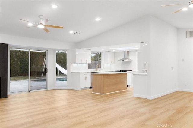 2173 N Viminal Rd, Palm Springs, CA 92262 - kitchen featuring wall chimney exhaust hood, ceiling fan, white cabinets, light countertops, and open floor plan