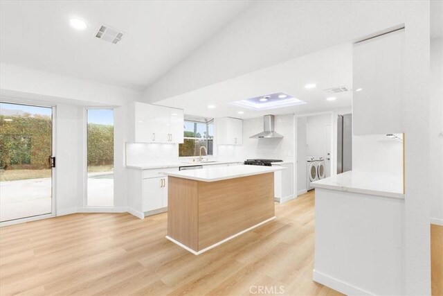 2173 N Viminal Rd, Palm Springs, CA 92262 - kitchen with wall chimney range hood, light countertops, white cabinetry, light wood finished floors, and recessed lighting