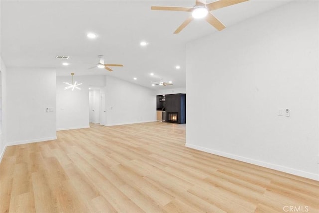 unfurnished living room featuring lofted ceiling, ceiling fan, and light hardwood / wood-style flooring