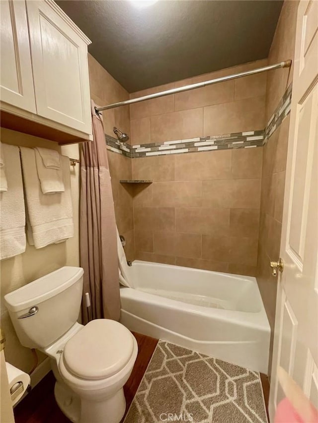 bathroom with shower / tub combo with curtain and toilet