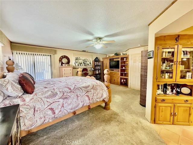 bedroom featuring ceiling fan, light carpet, and a textured ceiling