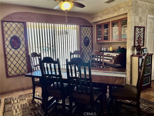 tiled dining area with ceiling fan