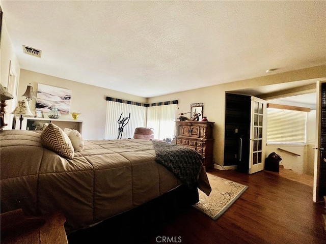 bedroom with a textured ceiling and dark hardwood / wood-style flooring