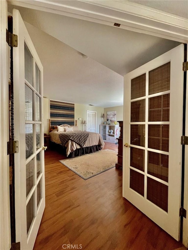 bedroom with french doors and wood-type flooring