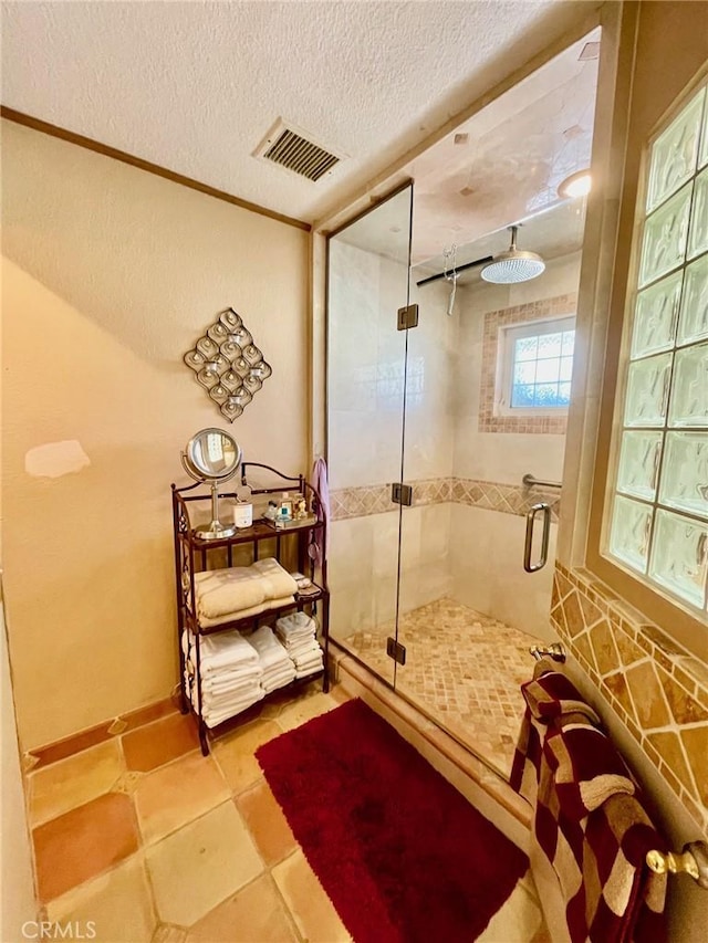 bathroom featuring a shower with door and a textured ceiling